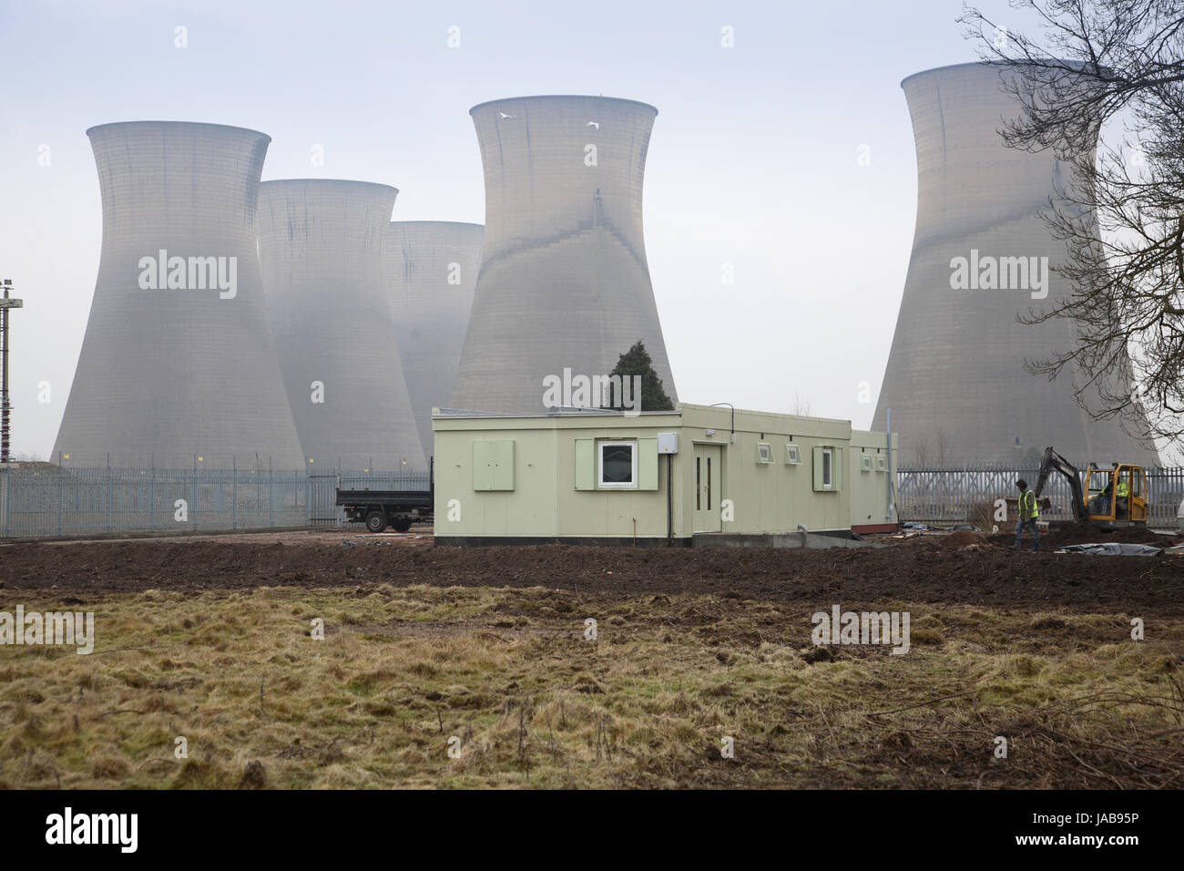 Temporary site cabins in front of the disused cooling towers of Willington Power Station, Derbyshire, UK. The power station was closed in the 1990s Stock Photo