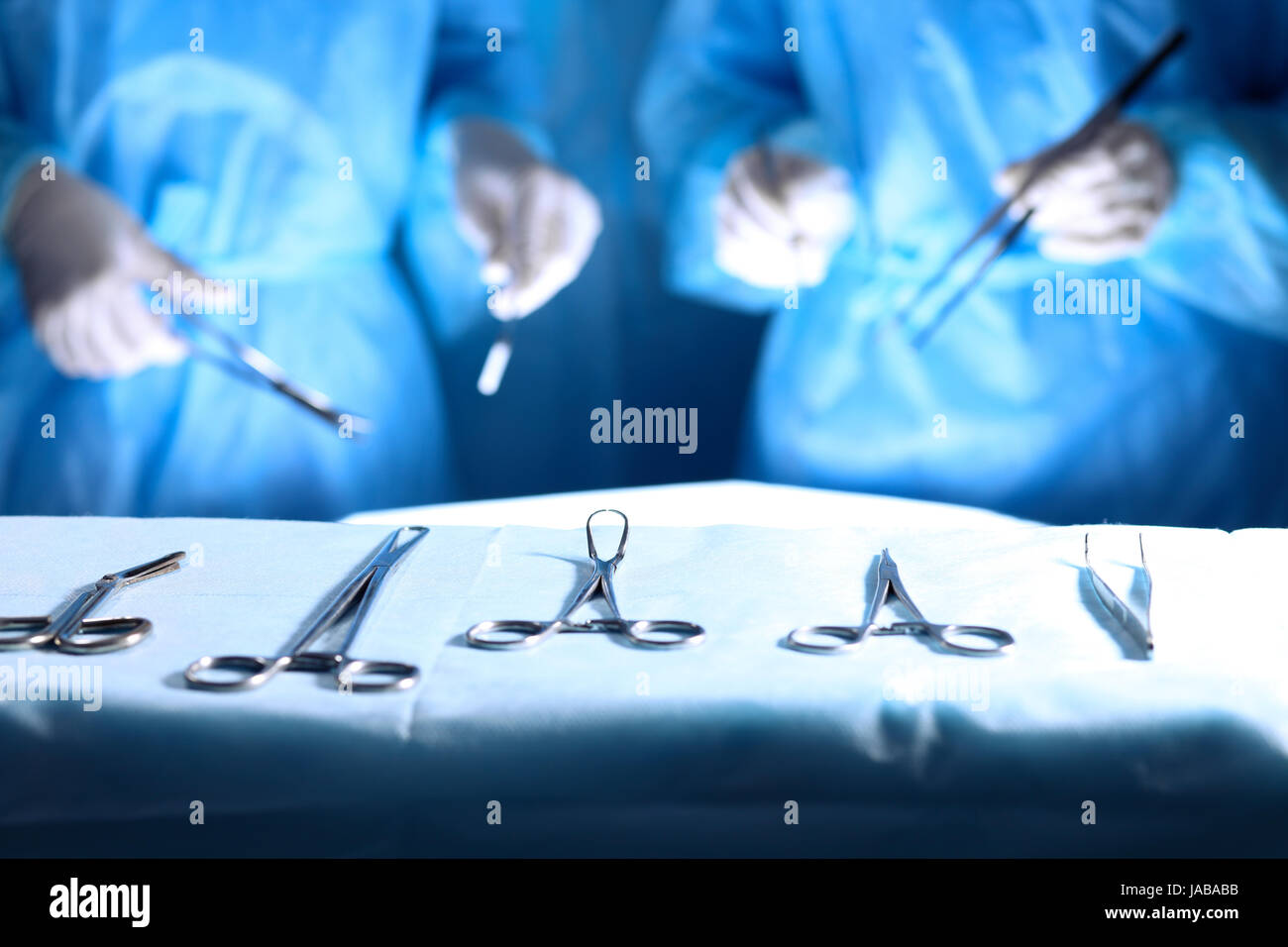 Surgical tools lying on the table while group of surgeons at background