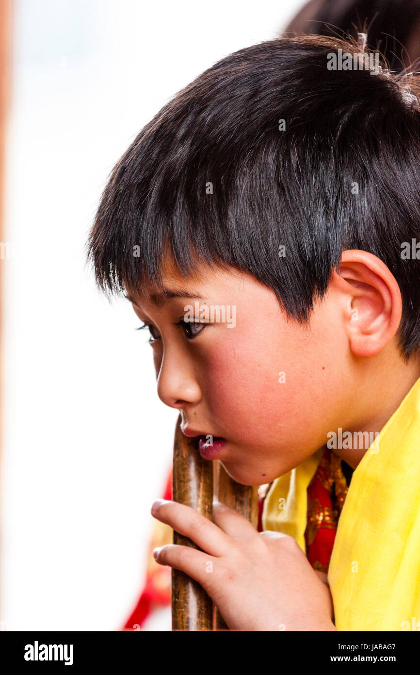 Japanese, Asian child, boy, 5-6 years old, side view head and shoulders, hands under chin, looking pensive and worried. Stock Photo