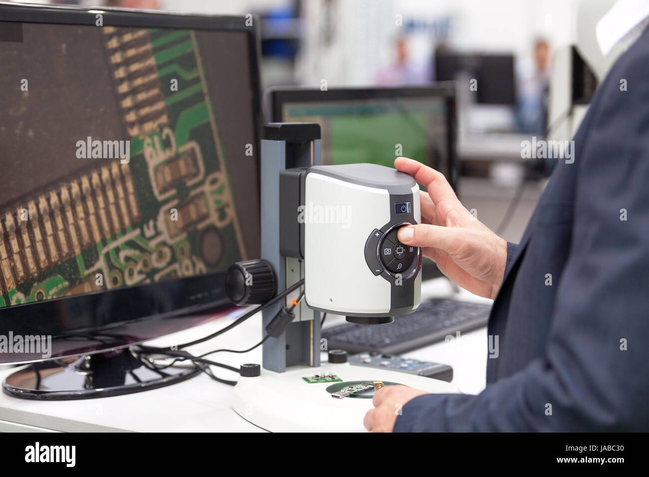 Operator working with digital microscope, inspecting electronic ...