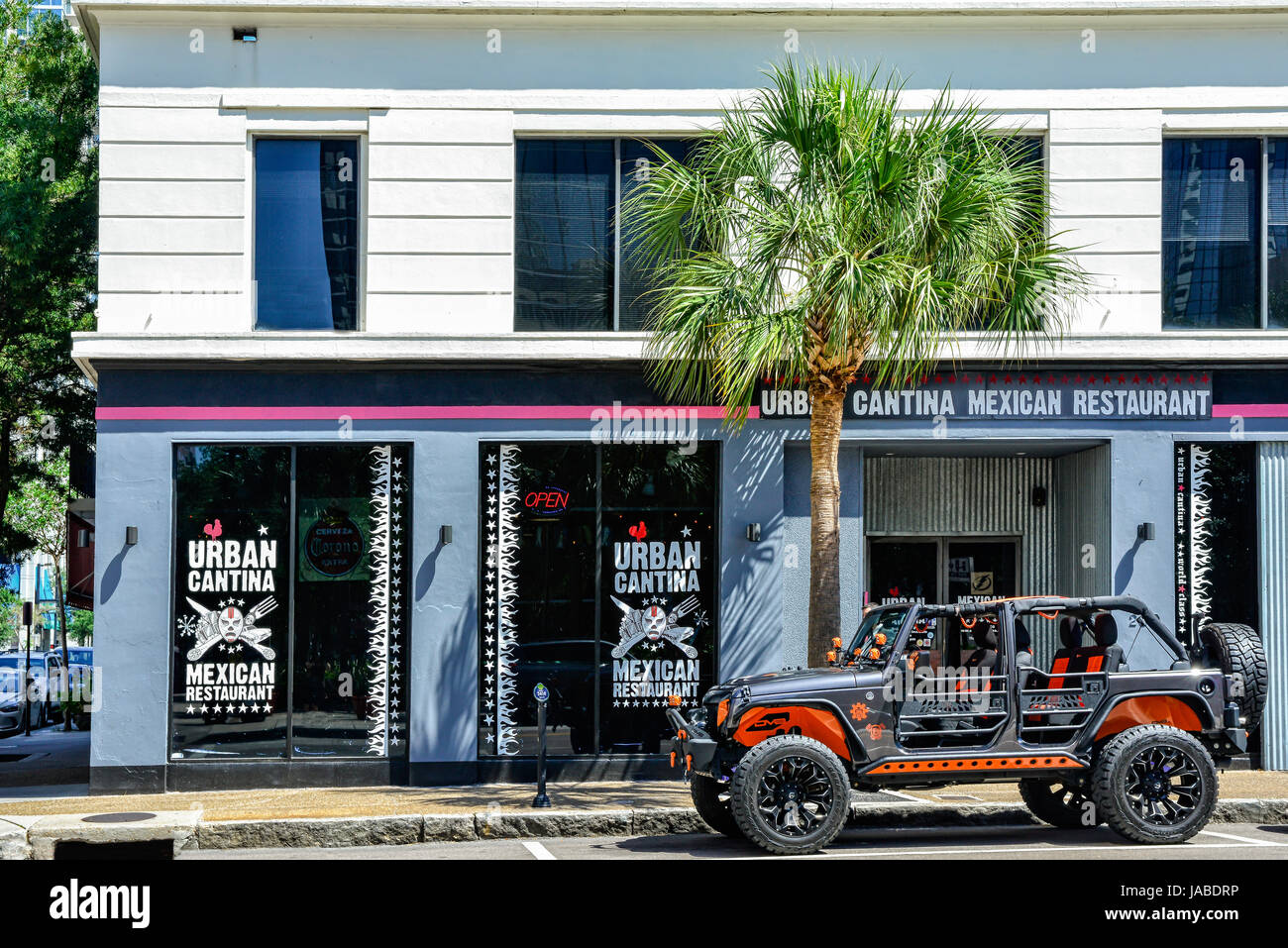 A customized off-road Jeep vehicle parked outside a trendy restaurant, the Urban Cantina, a Mexican Restaurant in downtown Tampa, FL Stock Photo