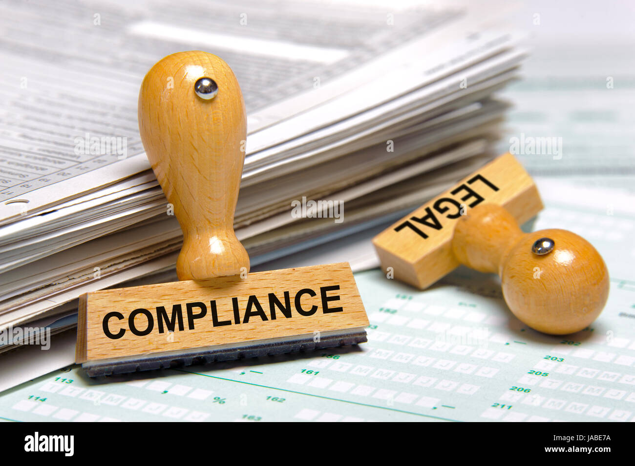 compliance and legal printed on stamps laying on stack of forms Stock Photo