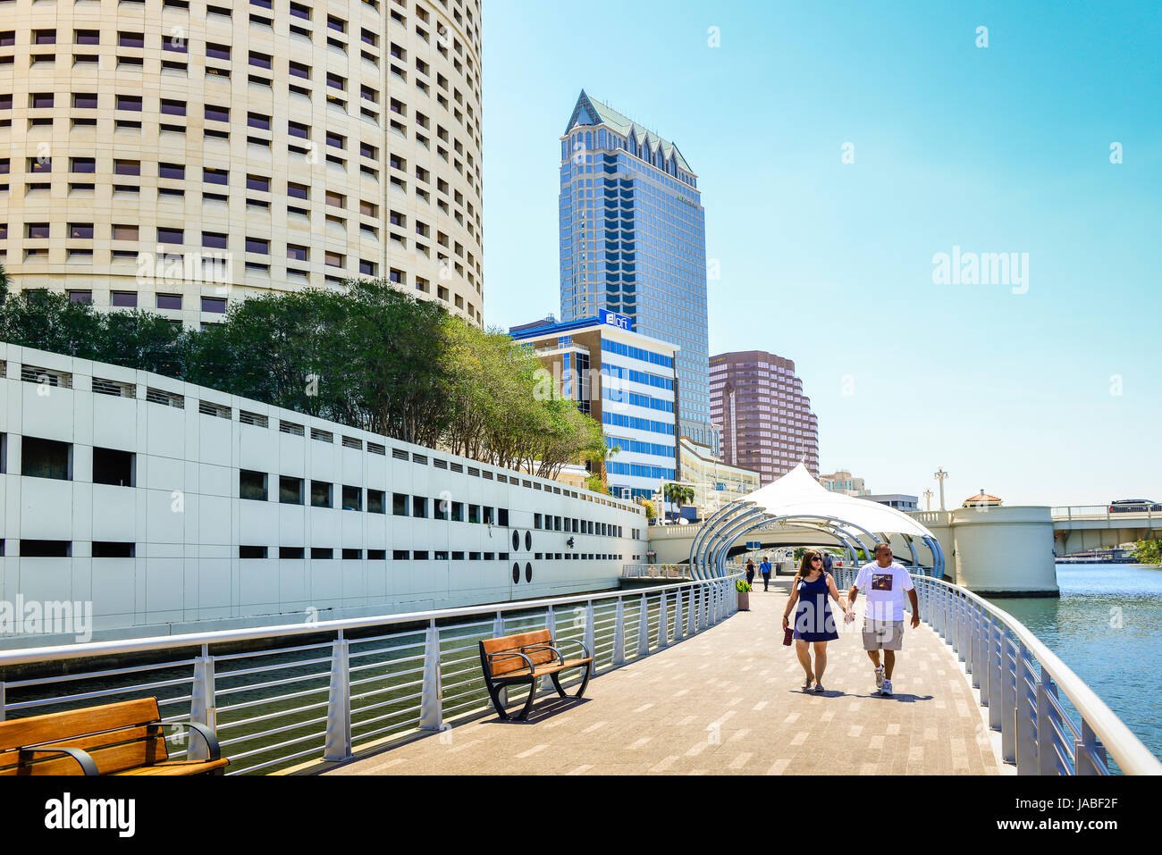 Pedestrians enjoy a stroll on the Tampa River Walk along the Hillsborough River with sunshade sails with many nearby attractions in Tampa, FL Stock Photo