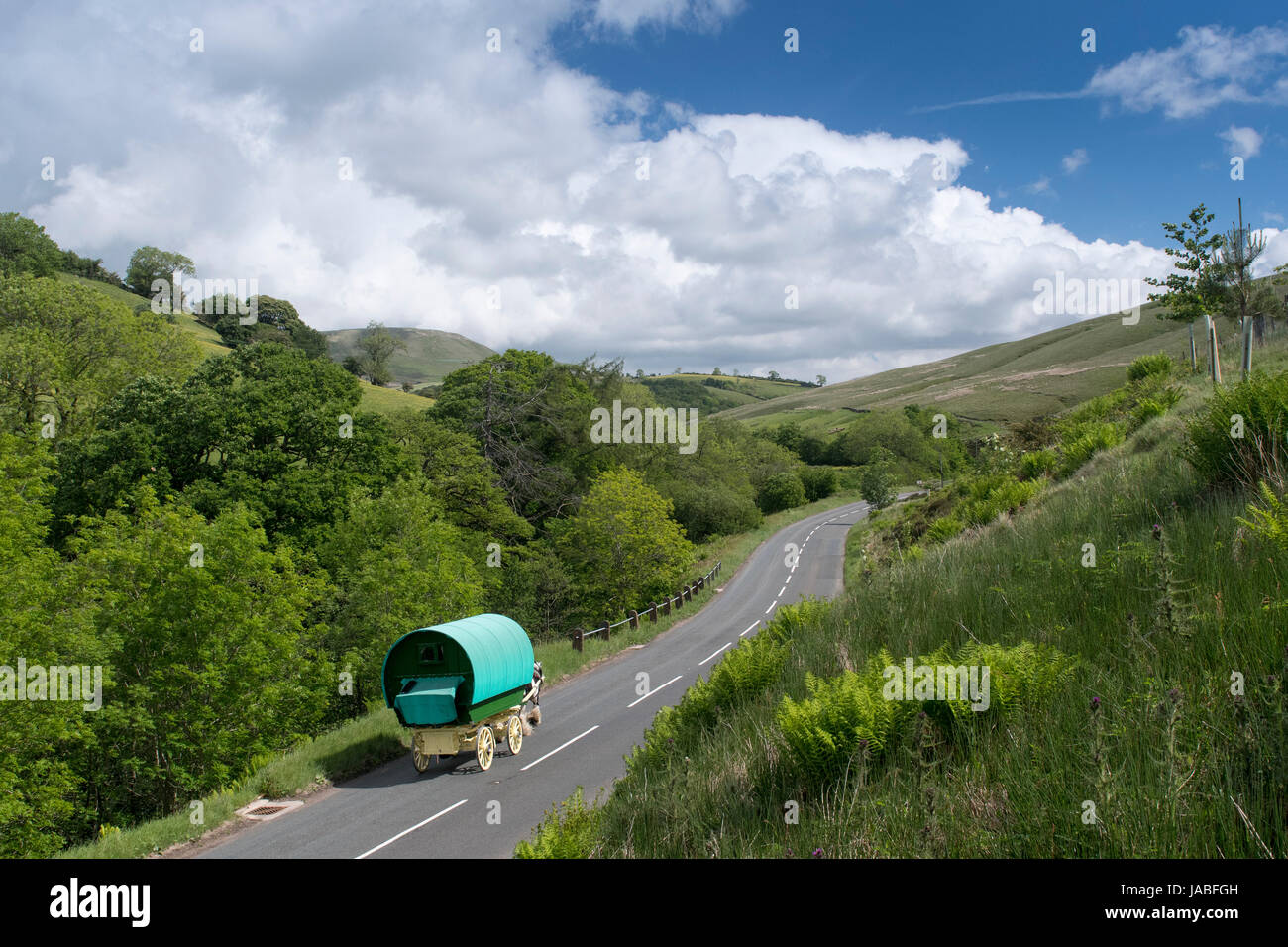 Gypsy travellers with horse drawn caravan on the A683 near Cautley, Cumbria, UK. Stock Photo