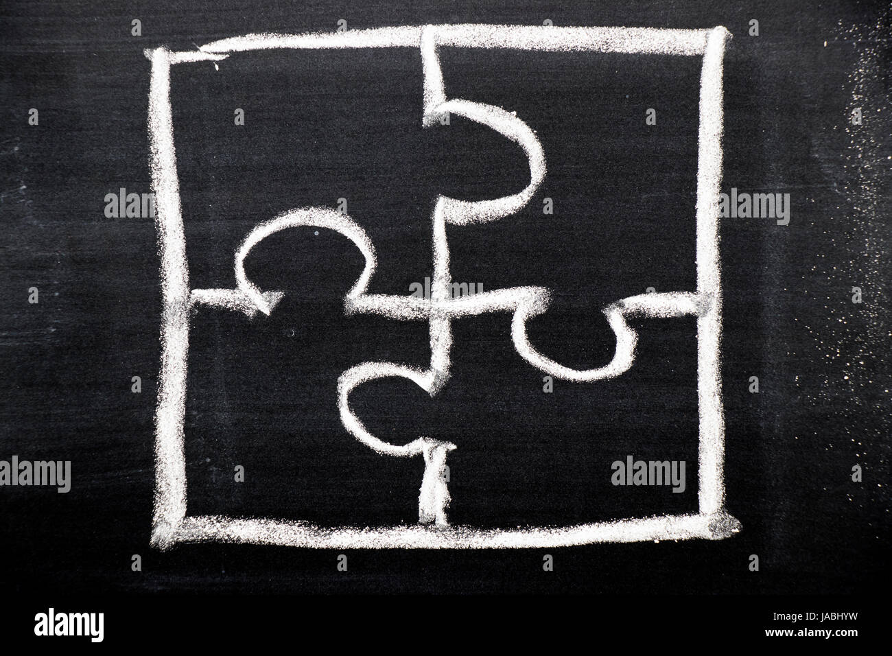 Chalk hand drawing as puzzle shape on black board background Stock Photo