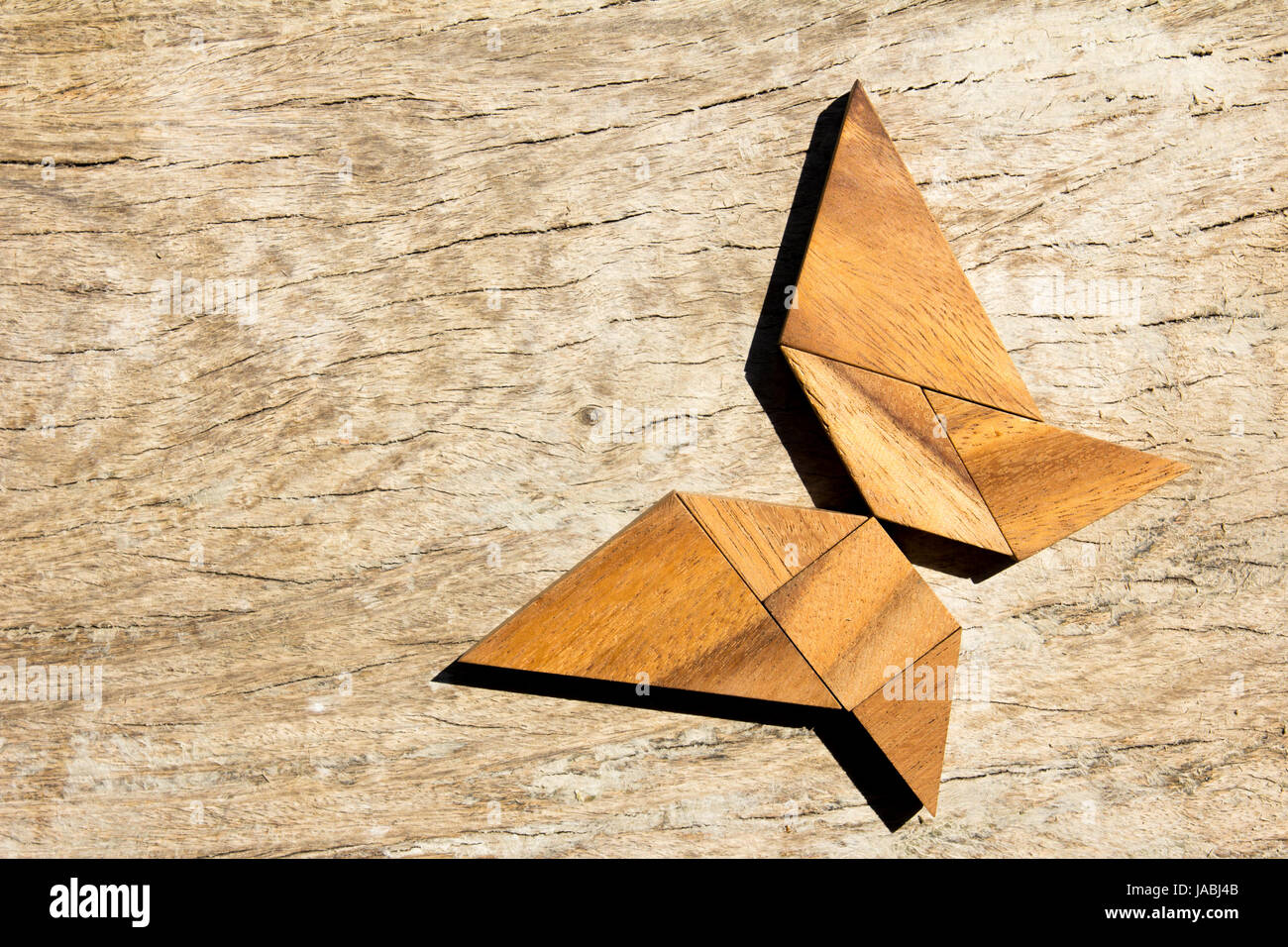 Wooden tangram puzzle in flying butterfly shape background Stock Photo