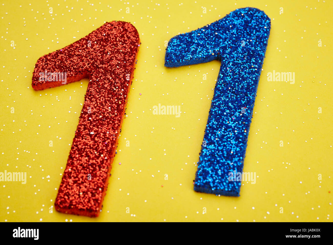 Number twelve red blue over a yellow background. Anniversary