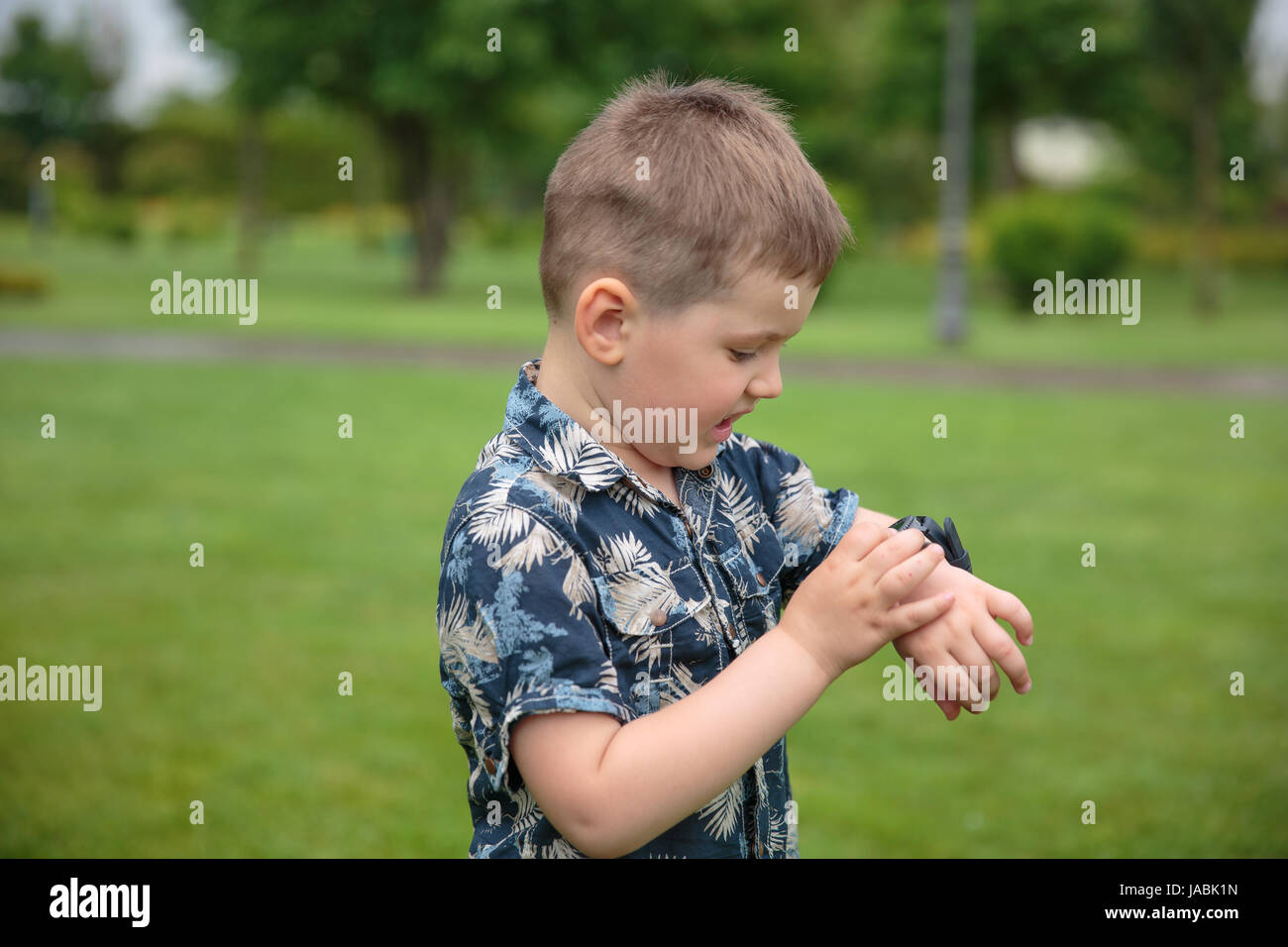 little boy considering watch on his hand Stock Photo