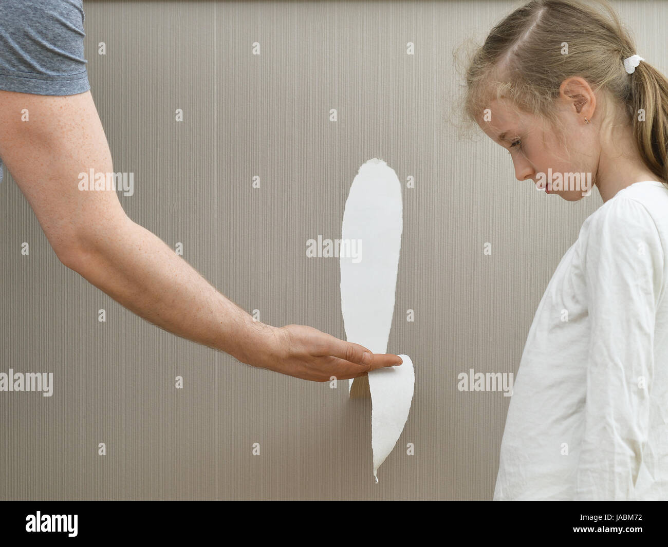 Little girl spoiled the wallpaper and her dad is angry. Stock Photo