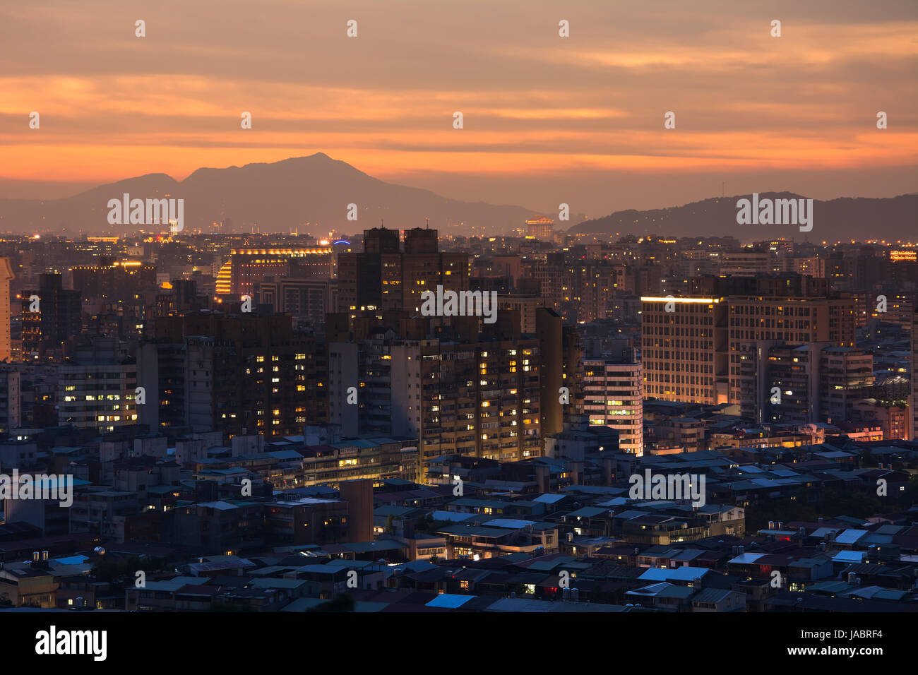 Sunset cityscape with dramatic clouds in orange and yellow color in