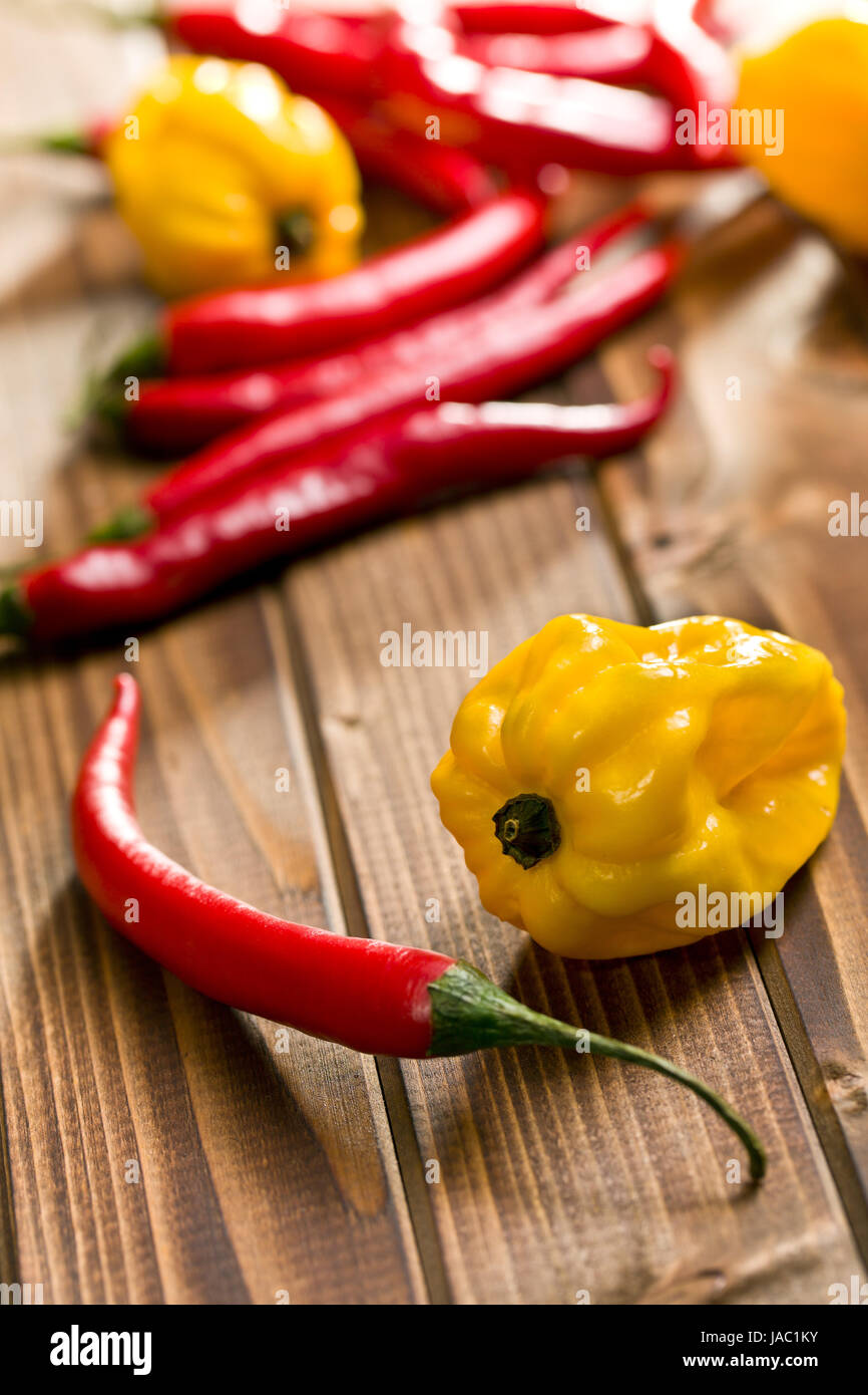 red chili peppers and yellow habanero on wooden background Stock Photo ...