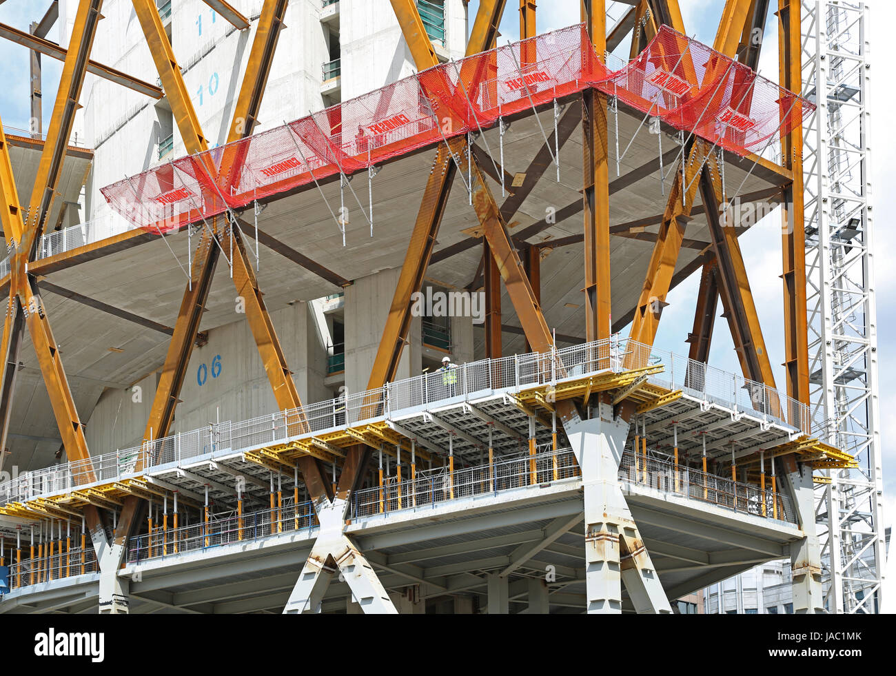 Construction of the Newfoundland building in London's Canary Wharf district. A workman stands on formwork within the diagonal, structural steel frame. Stock Photo