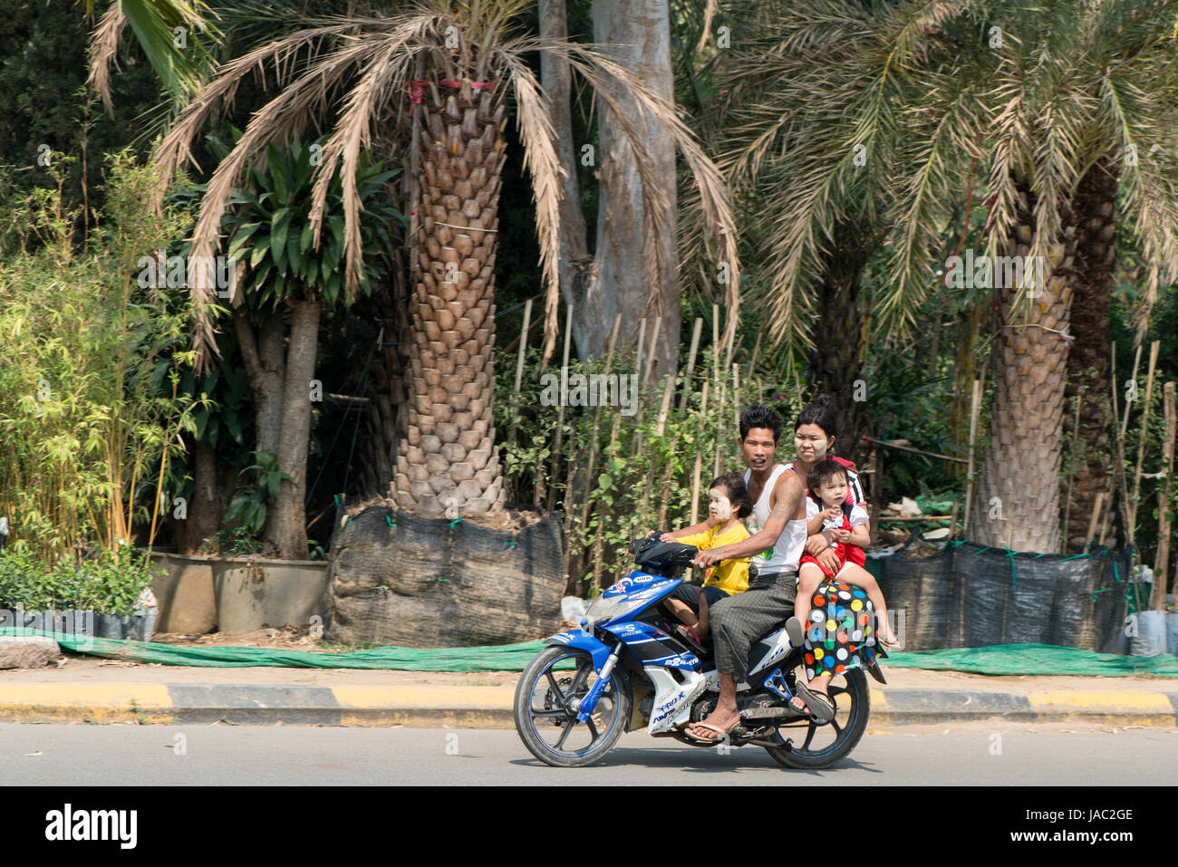 A family ride on a motorbike in Mandalay, Myanmar (Burma) Stock Photo