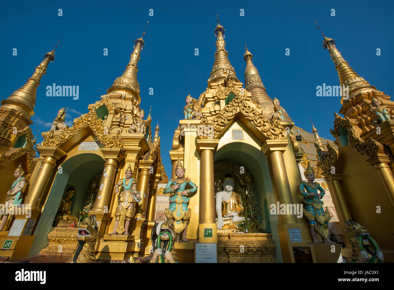 Shrines containing sitting Buddhas surround the main Pagoda at the Shwedagon Pagoda in Yangon (Rangoon), Myanmar (Burma) Stock Photo