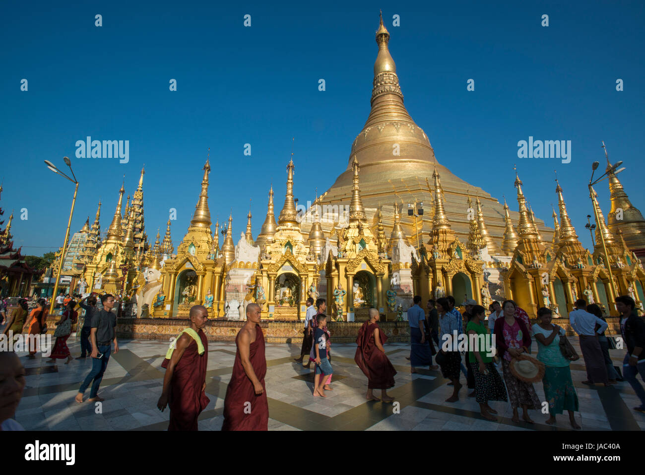 Pilgrims and monks make their way around the Shwedagon Pagoda in Yangon (Rangoon), Myanmar (Burma) Stock Photo