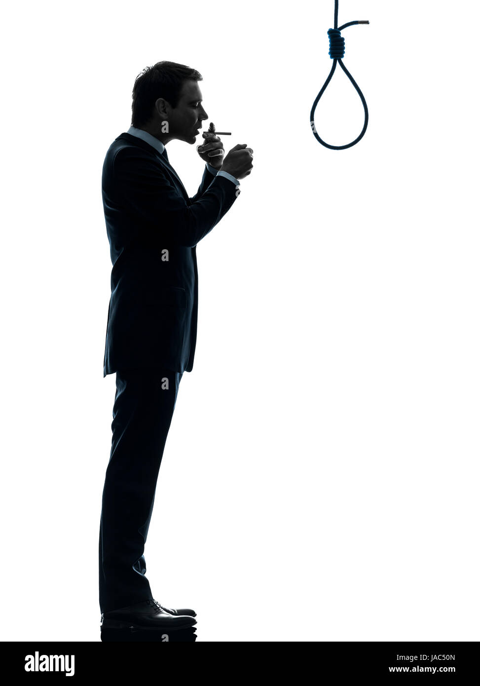 one caucasian man smoking cigarette standing in front of hangman's noose in  silhouette studio isolated on white background Stock Photo