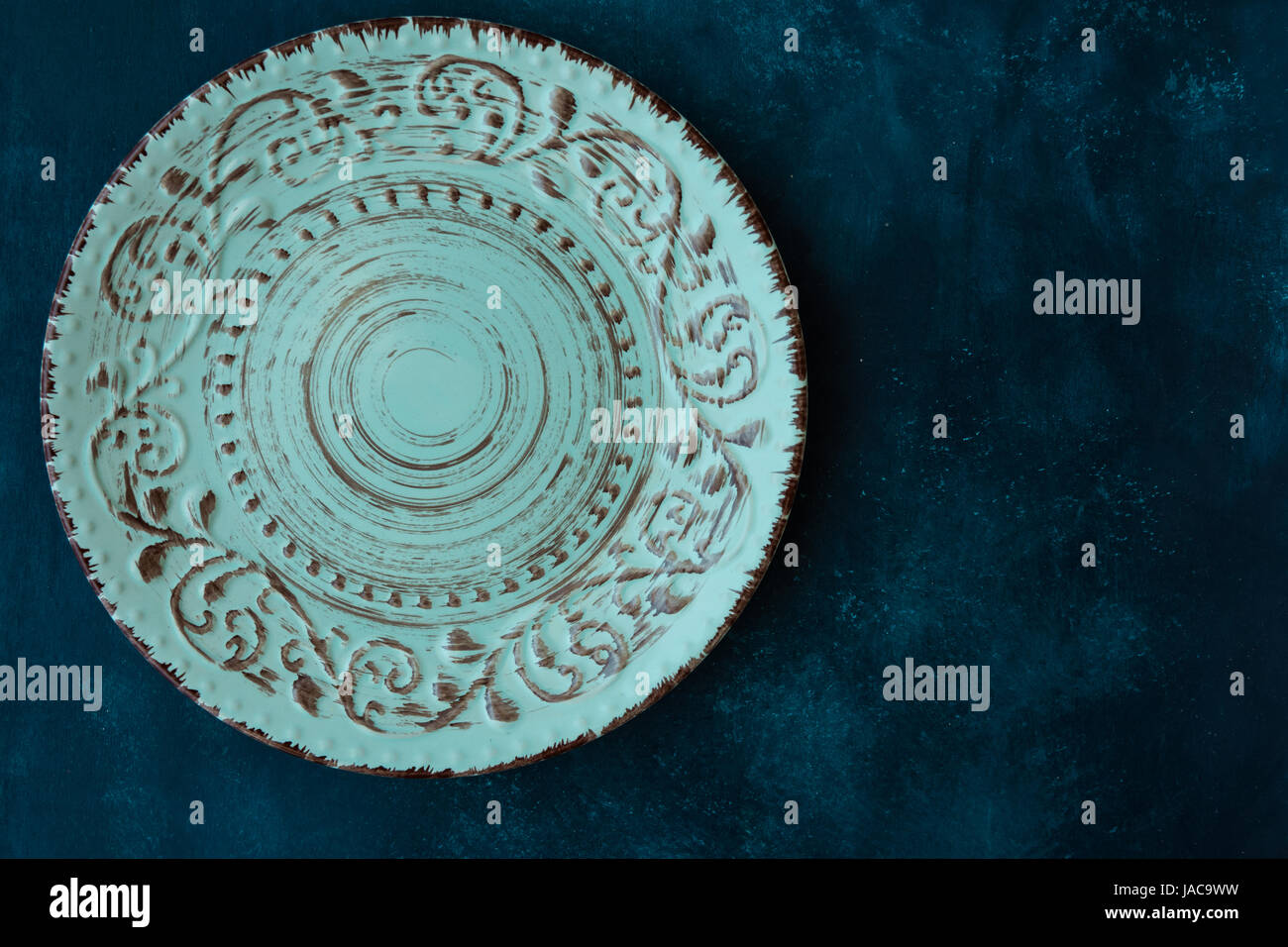 Turquoise vintage empty plate, on dark blue concrete table top, flat lay, menu template, copyspace, top view, styled Stock Photo