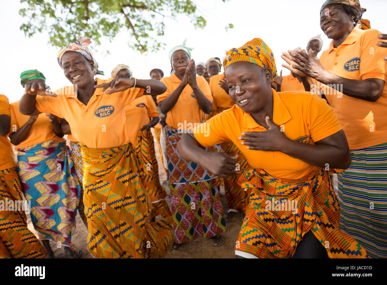 Members of women’s SILC group (Savings and Internal Lending Community) dance together during a meeting Upper East Region, Ghana. Stock Photo