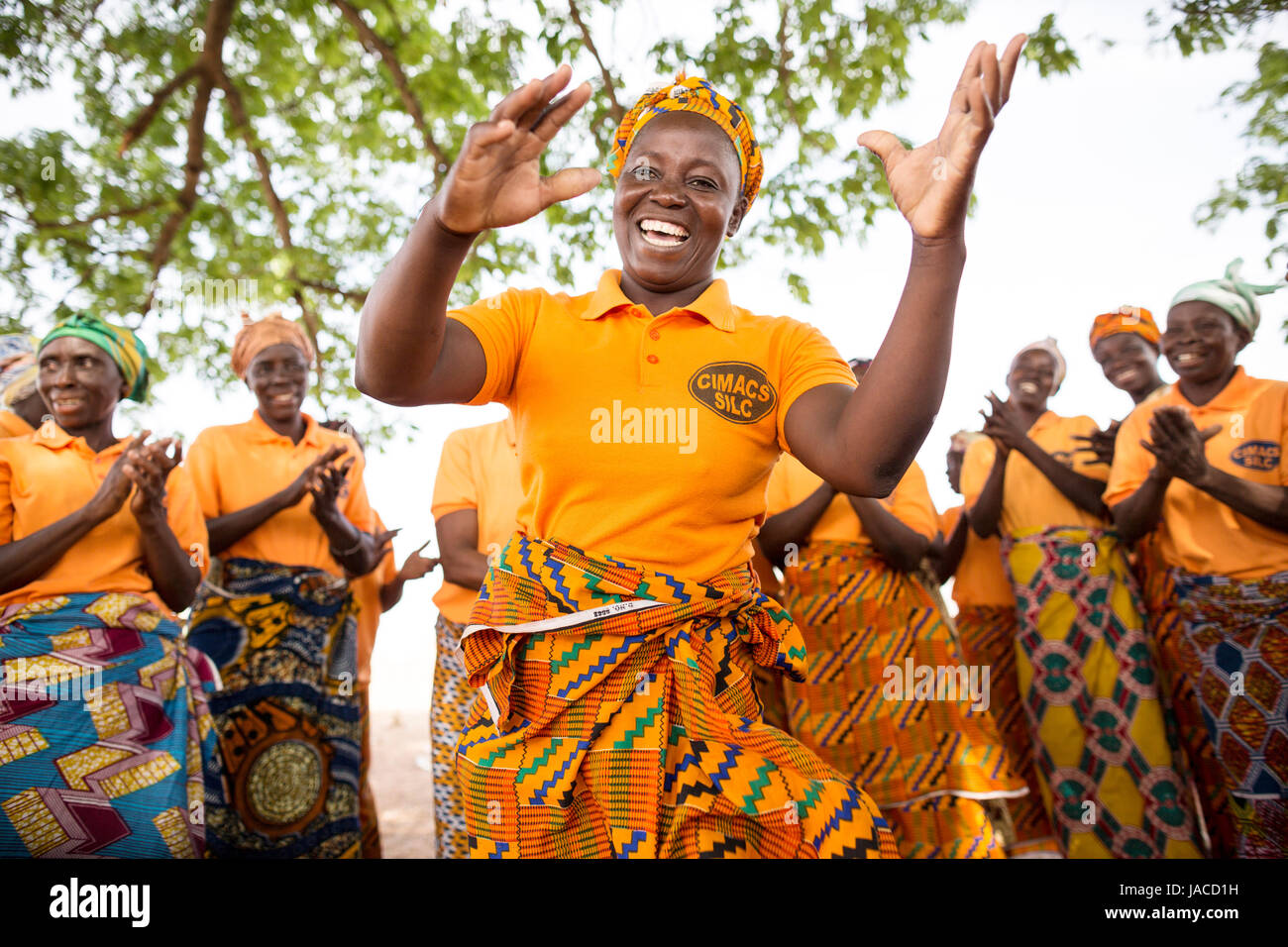 Members of women’s SILC group (Savings and Internal Lending Community) dance together during a meeting Upper East Region, Ghana. Stock Photo