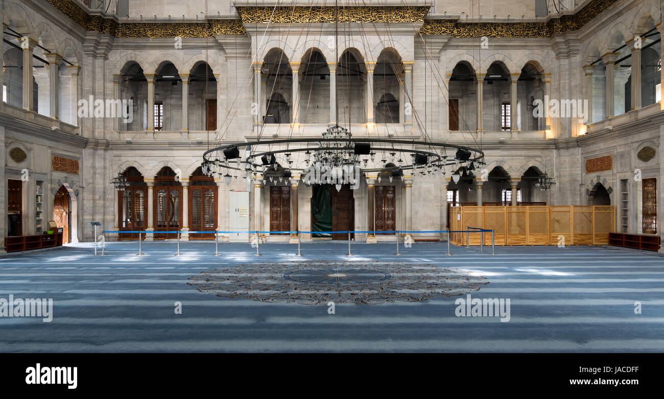 Interior of Nuruosmaniye Mosque, an Ottoman Baroque style mosque completed in 1755, with arcades, wooden doors, windows, and blue carpet, located in S Stock Photo