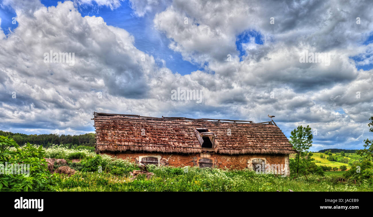 Blue cloudy sky over stork sitting on the edge of barn, HDR image, Poland, Europe Stock Photo