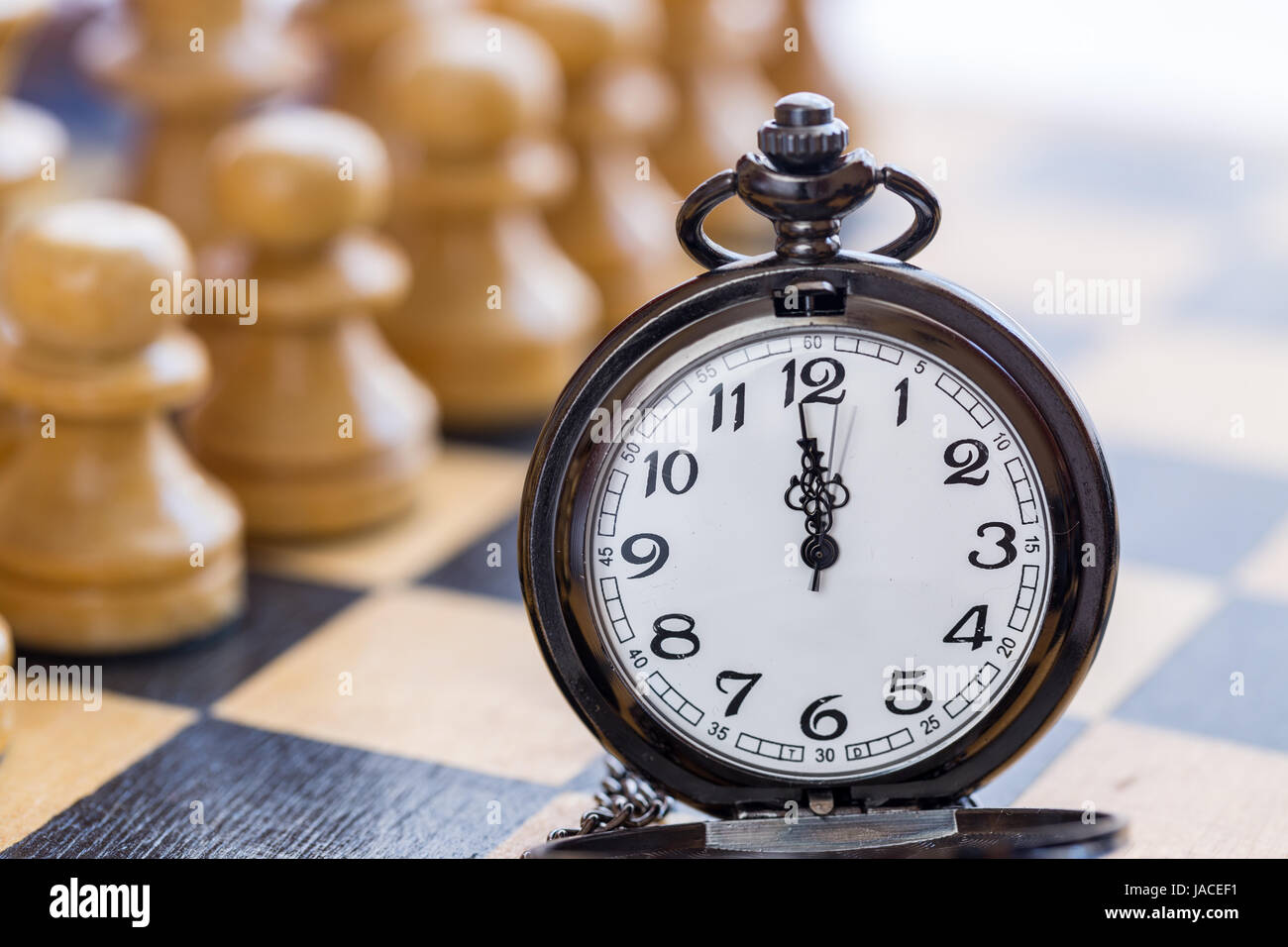 Pocket watch and chess pieces Stock Photo Alamy