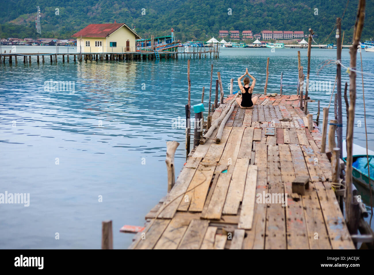 Summer yoga session on a pier - Koh Chang Bang Bao fisherman village, Meditation - lotus pose - padma asana. Activity in south east Asia Stock Photo