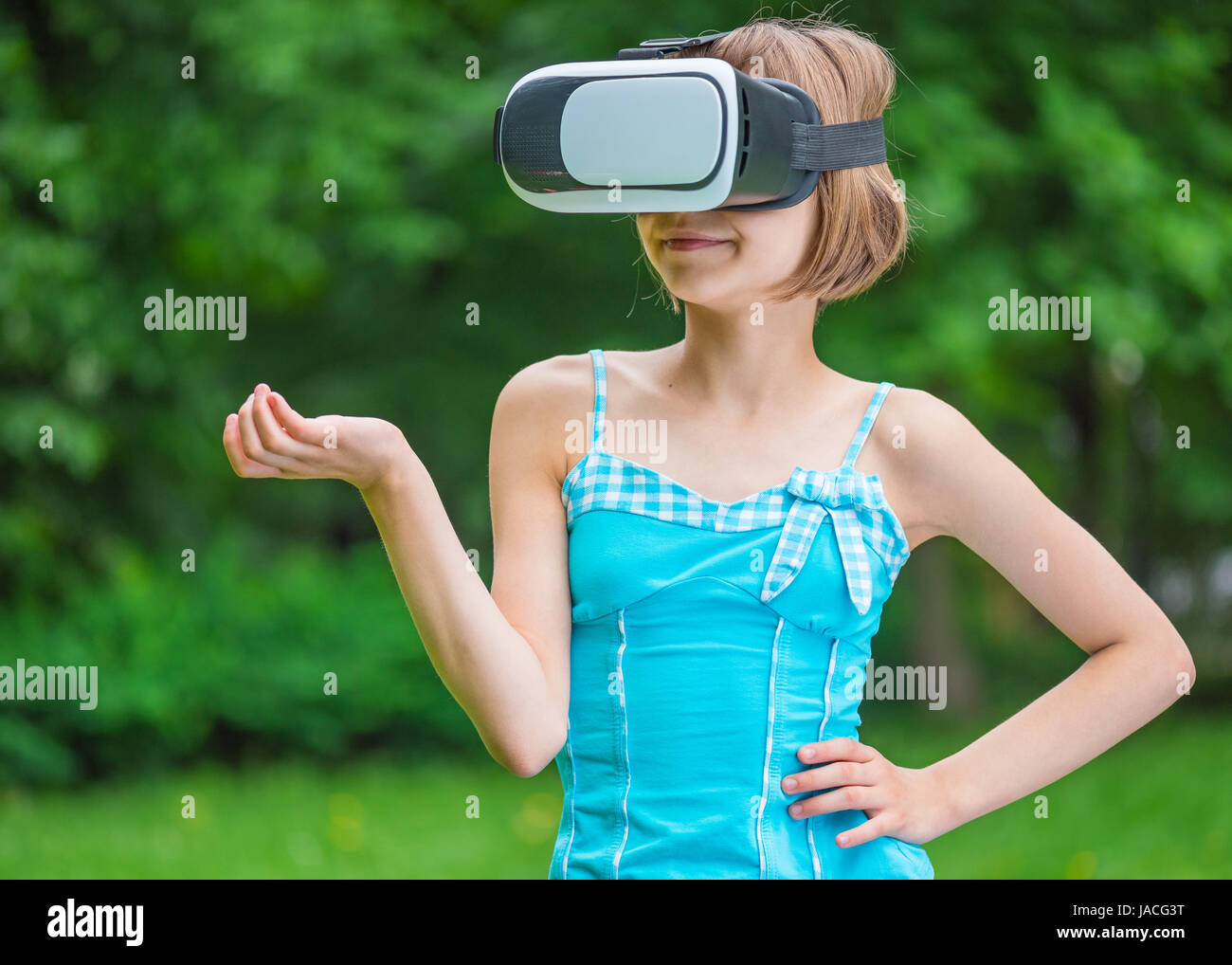 Little girl with VR glasses in park Stock Photo
