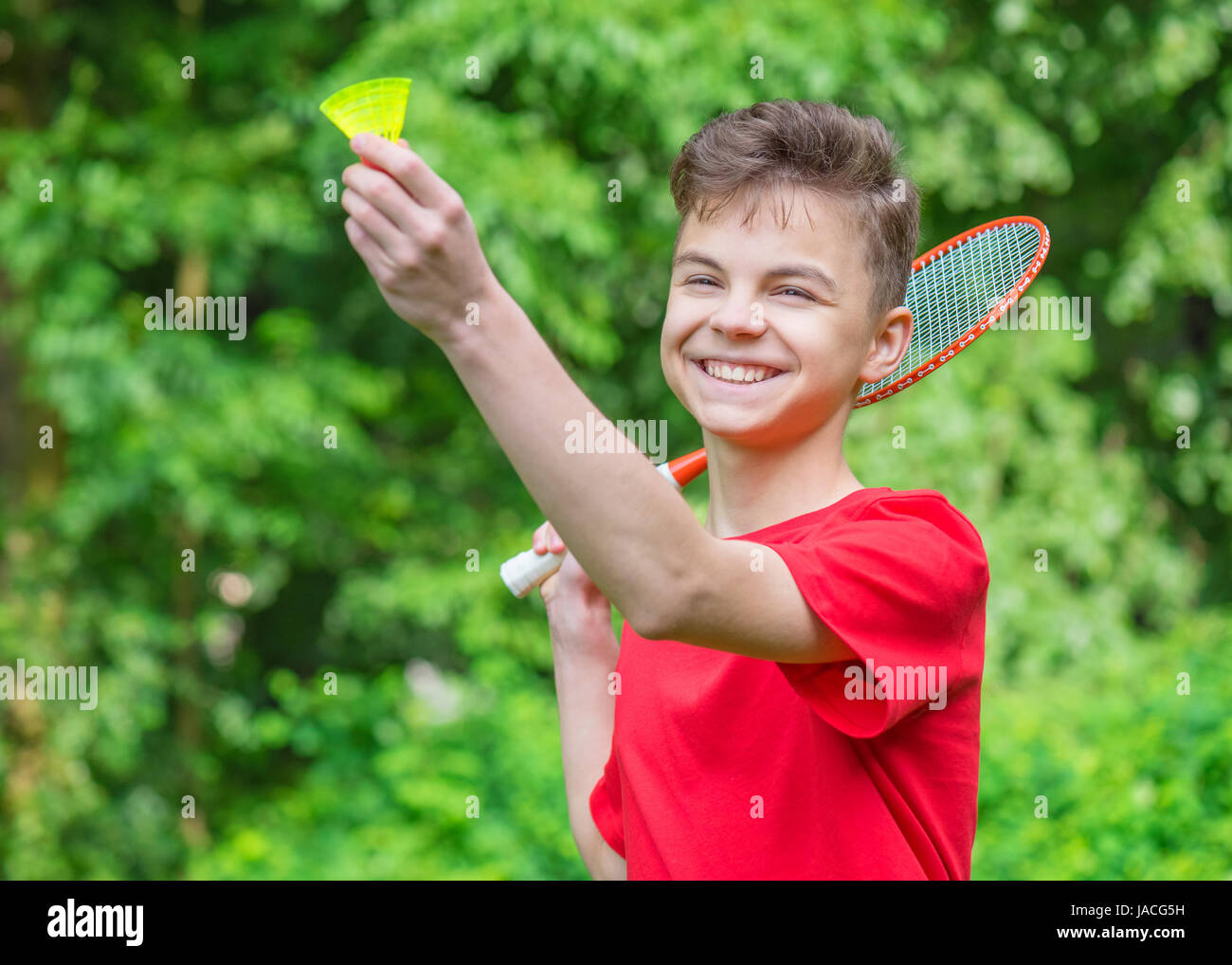 Teen boy playing badminton in park Stock Photo