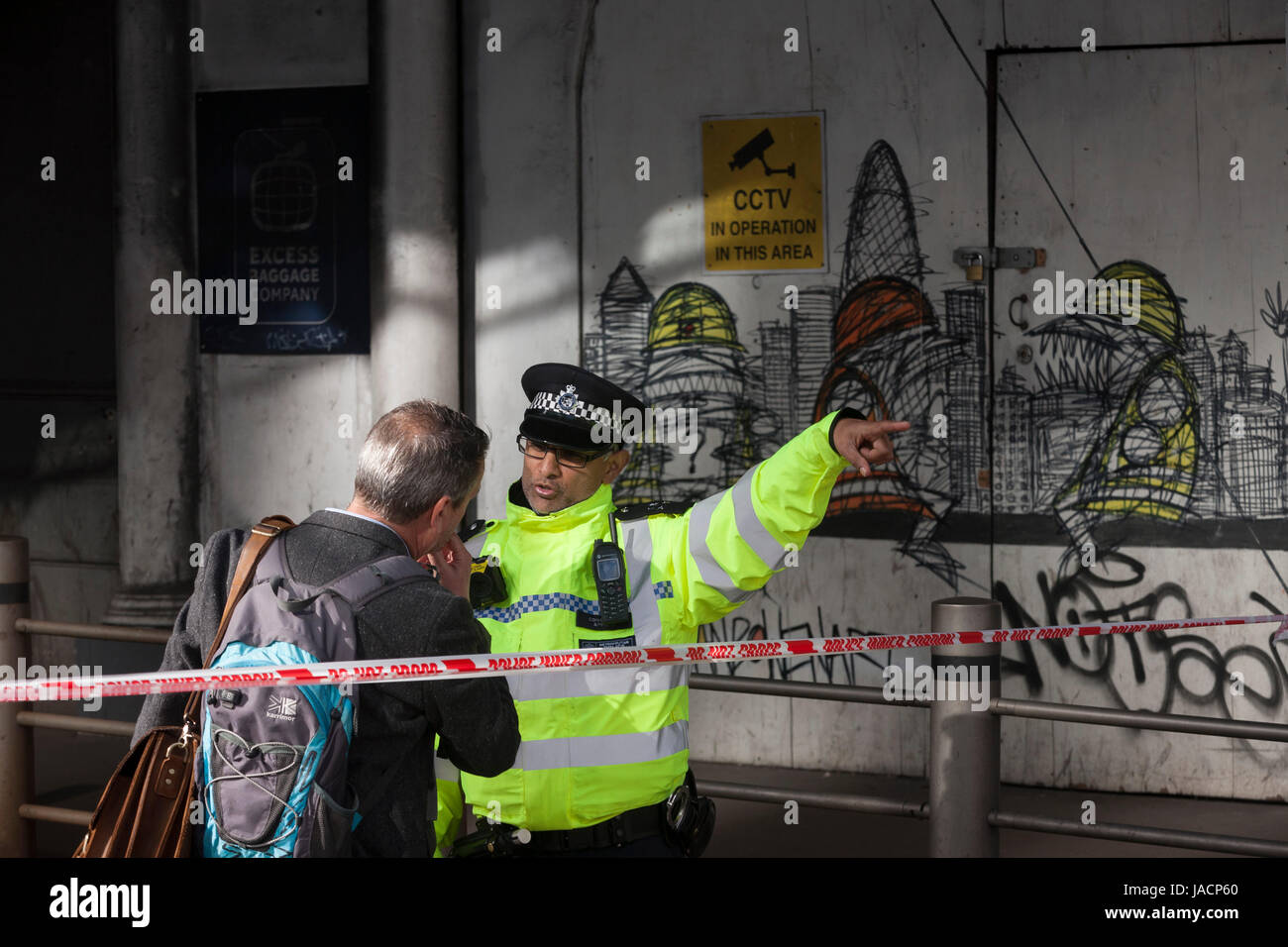 36 hours after the London Bridge and Borough Market terrorist attack, the capital returns to normality and Londoners return to their first day to work so Police officers help with directions as roads are still closed to traffic and pedestrian use, on Monday 5th June 2017, in the south London borough of Southwark, England. Seven people were killed and many others left with life-changing injuries - but the British spirit of defiance and to carry on with every day life, endures. Stock Photo