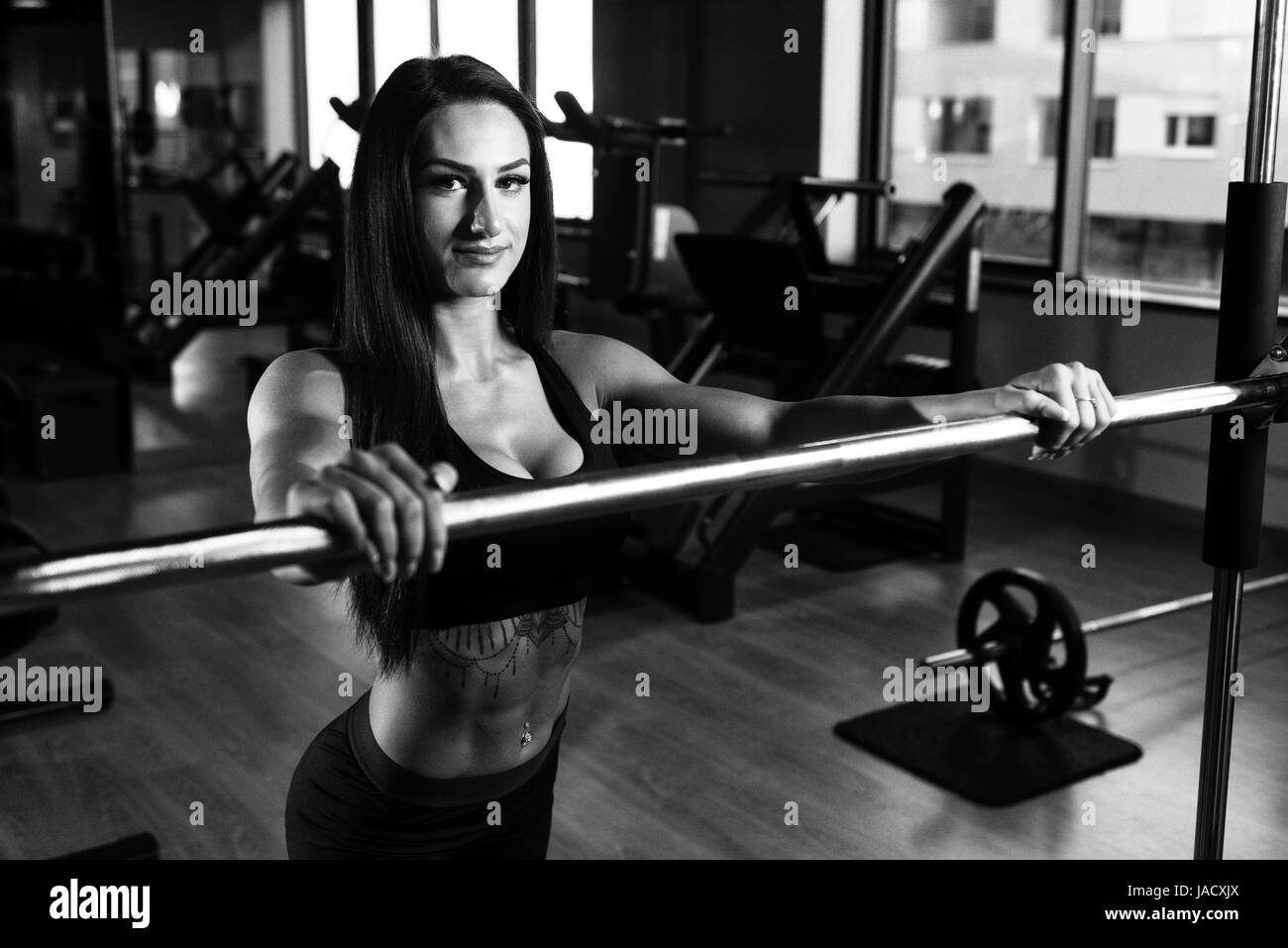 Healthy Fitness Woman Preparing To Working Out Legs With Barbell In A Gym - Squat Exercise Stock Photo