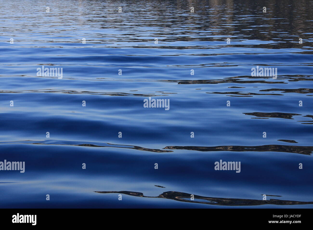 Ripples on a blue water background Stock Photo - Alamy
