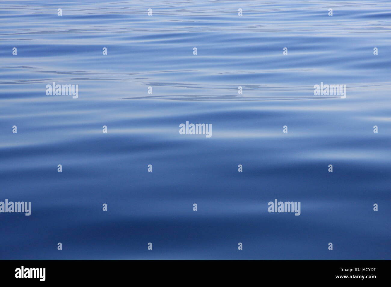 Ripples on a blue water background Stock Photo - Alamy