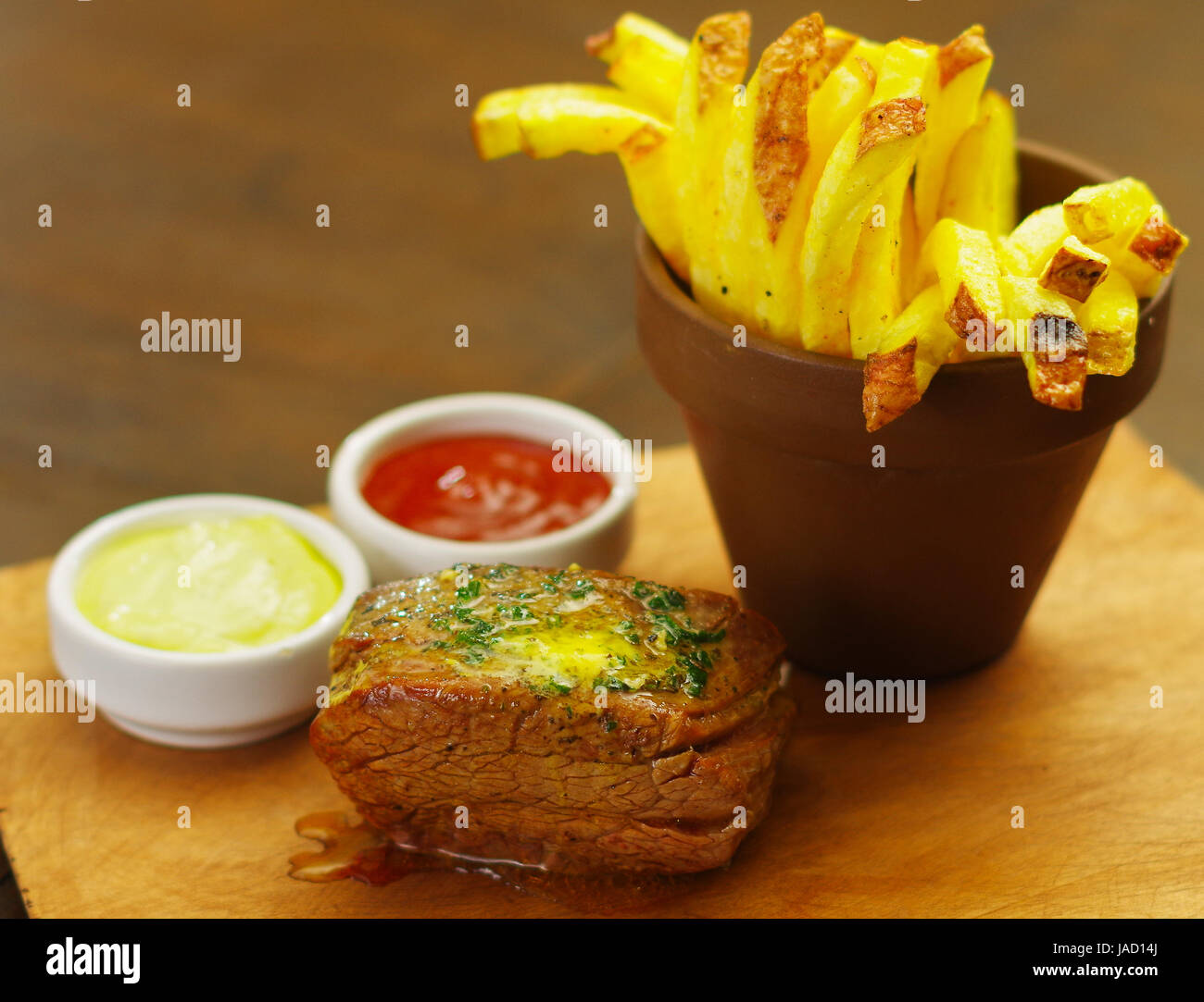 Welldone grilled marinated beef flank steak with ketchup, mustard and