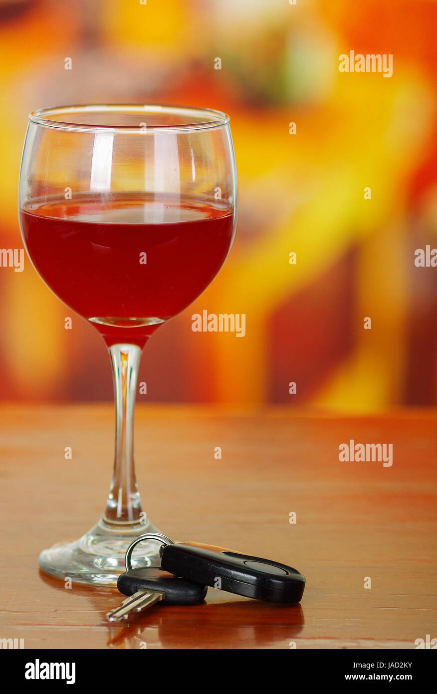 Close up of a cup of red wine with car keys on wooden table Stock Photo