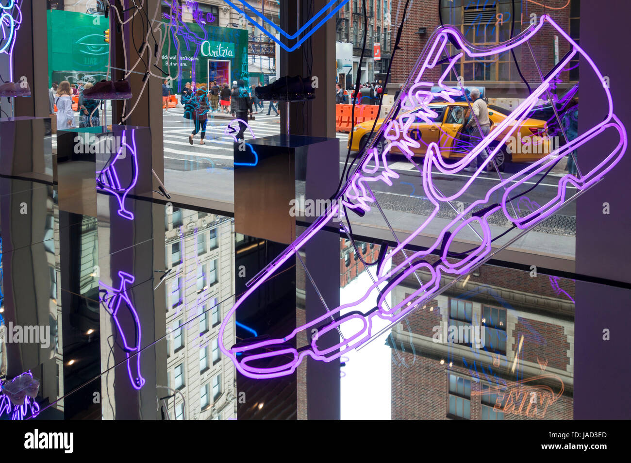 A multi-leveled view from inside the Nike showplace store in SoHo, New York City displays neon illustrations, reflections, and life on Spring Street Stock Photo