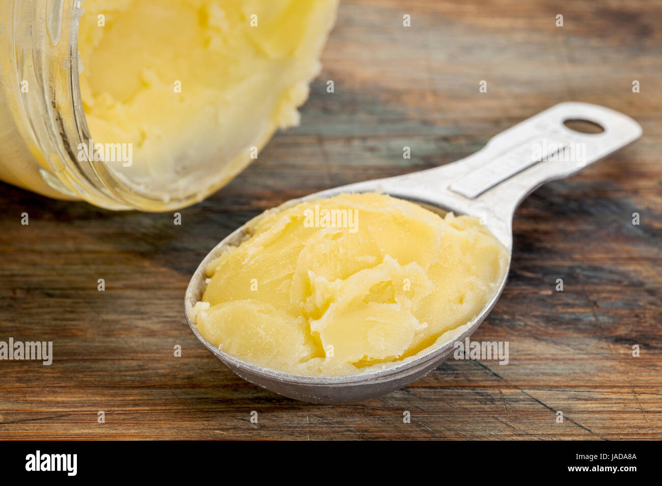 jar and measuring tablespoon of ghee clarified butter Stock Photo Alamy