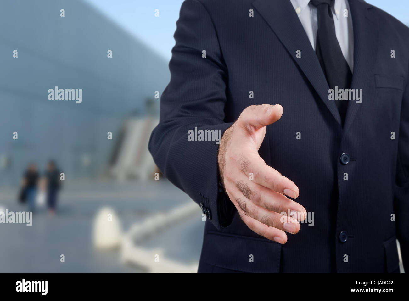 businessman in blue suit holding out his hand to make a deal, isolated on a white background Stock Photo