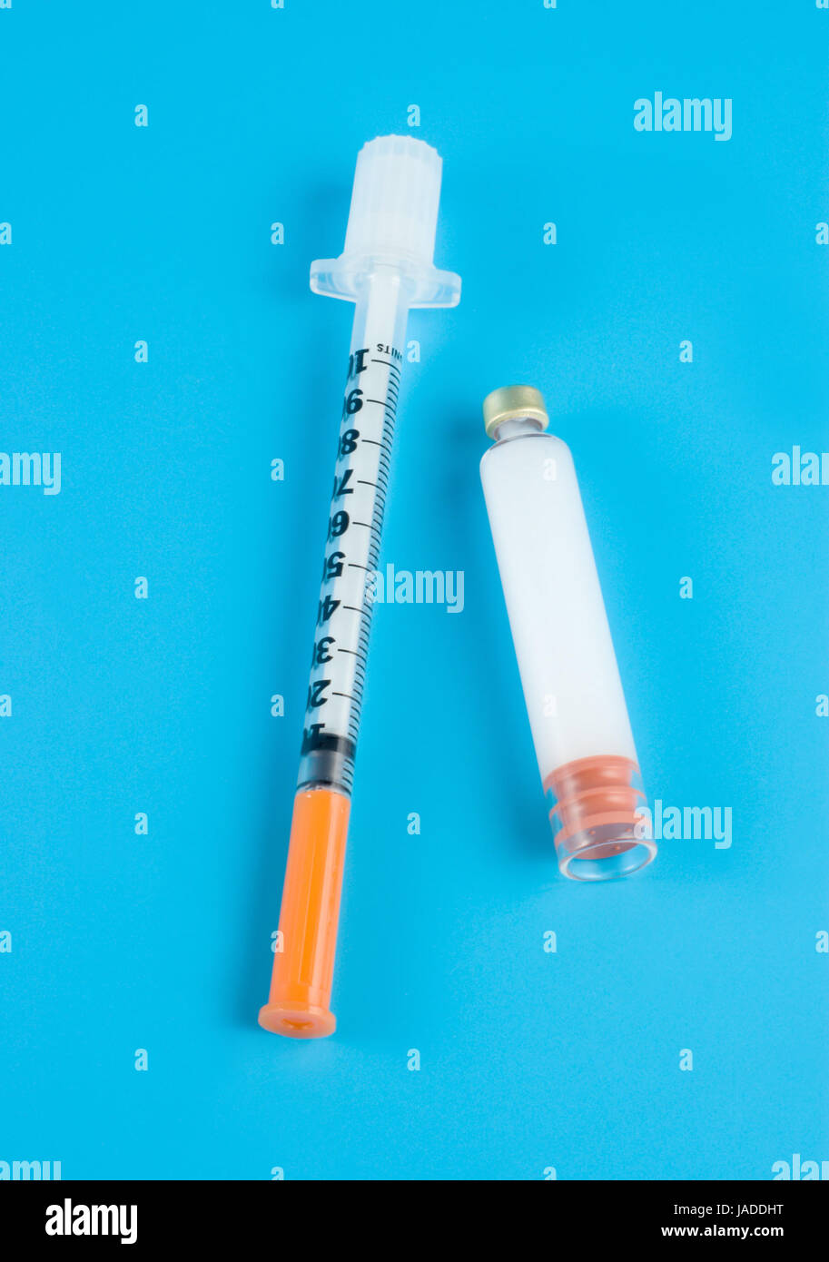 Insulin and syringe on a blue background Stock Photo - Alamy