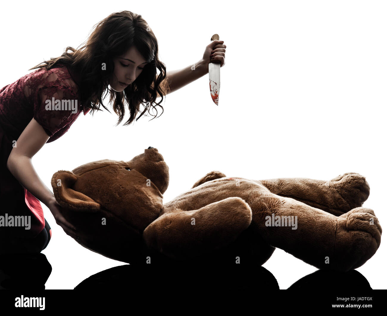 one caucasian strange young woman killing her teddy bear  in silhouette white background Stock Photo