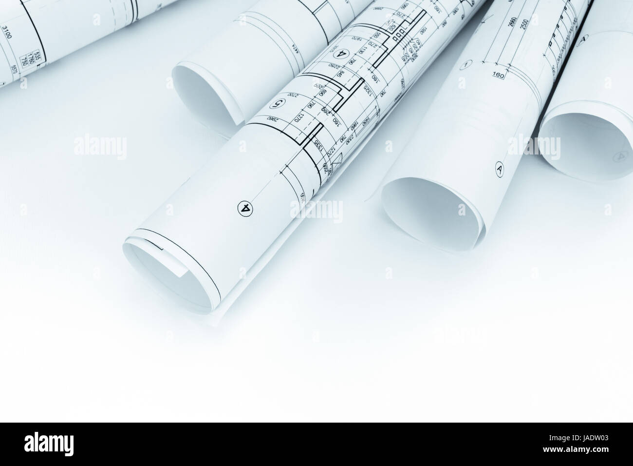 rolls of architectural blueprints and floor plans on white background ...