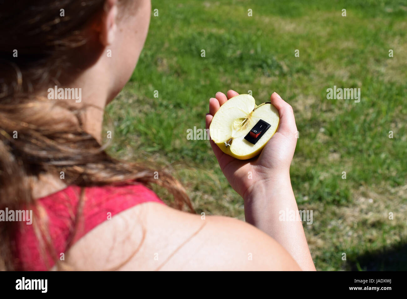 Unique healthy food concept. Hand holding apple with inserted power switch as meaning a change to healthier life. Stock Photo