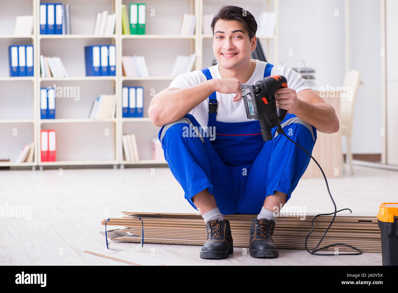 Young worker working on floor laminate tiles Stock Photo - Alamy