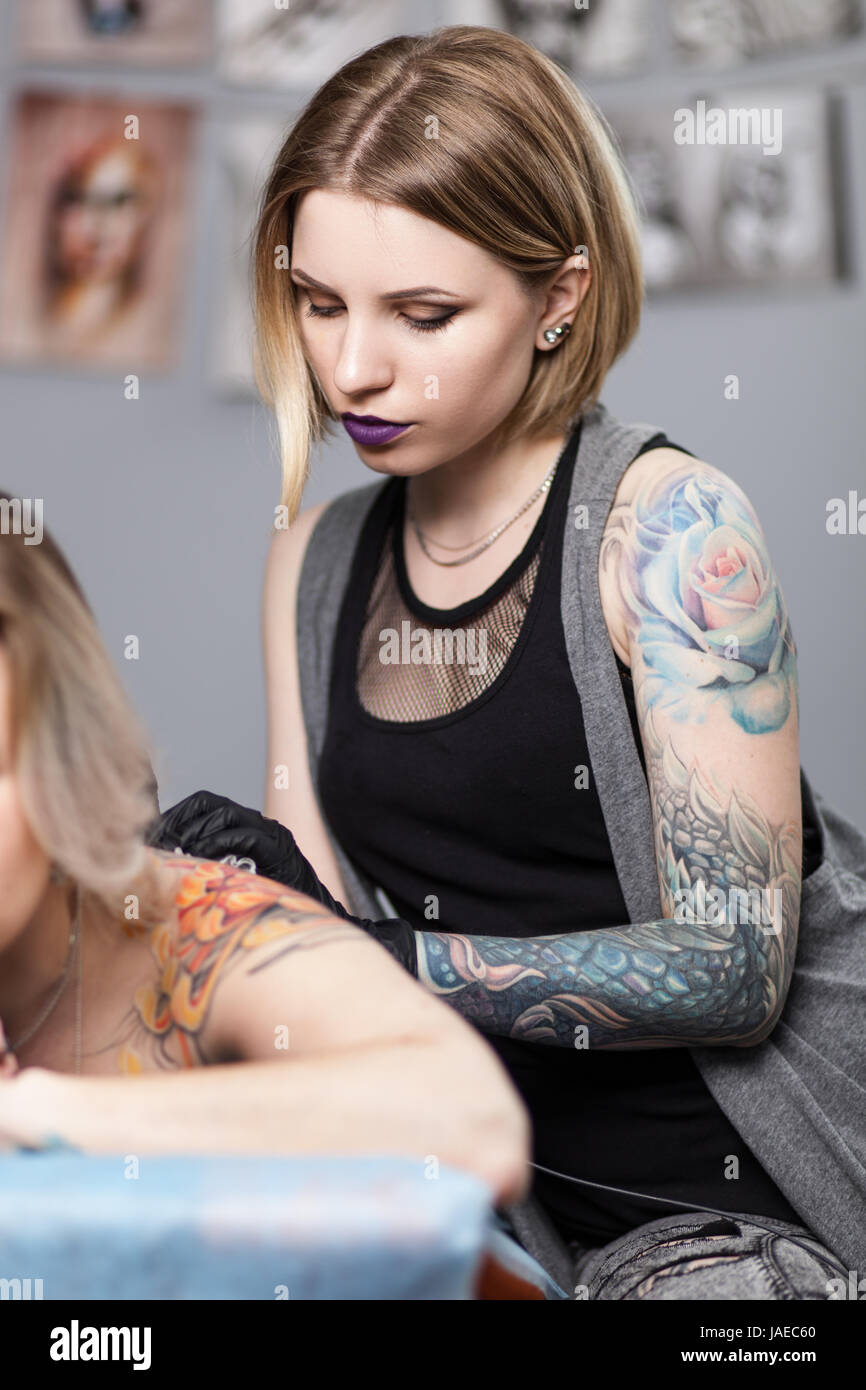 Tattoo artist with a client in a studio Stock Photo