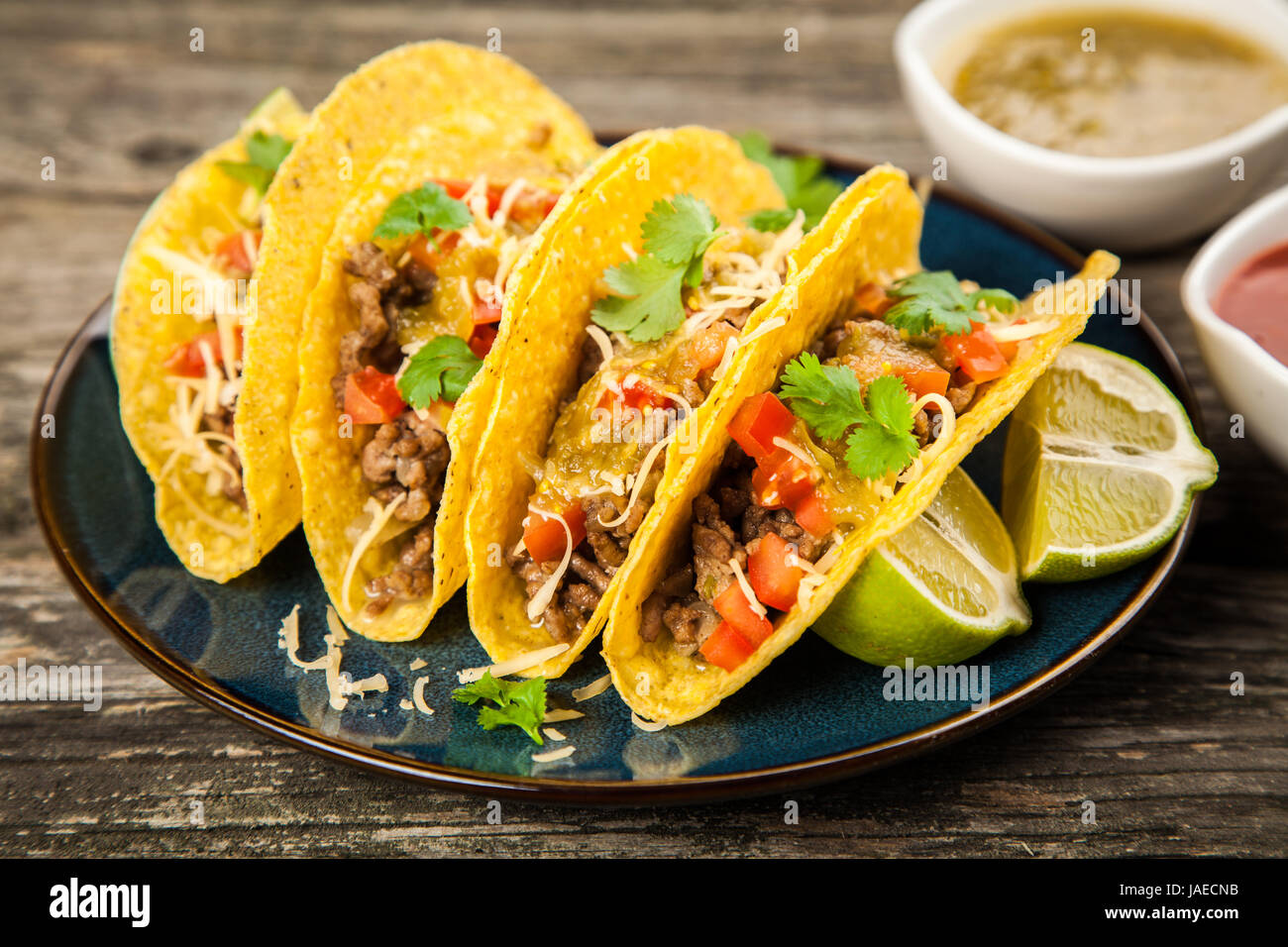 Mexican tacos with beef, cheese, tomato and green salsa Stock Photo - Alamy
