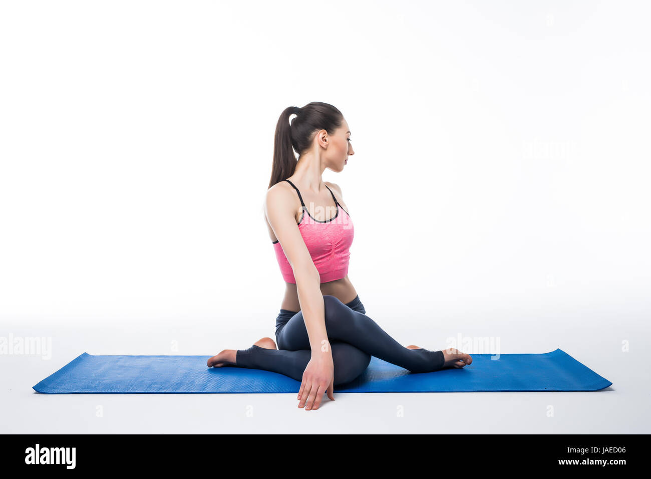 Sporty young woman doing yoga practice isolated on white background ...