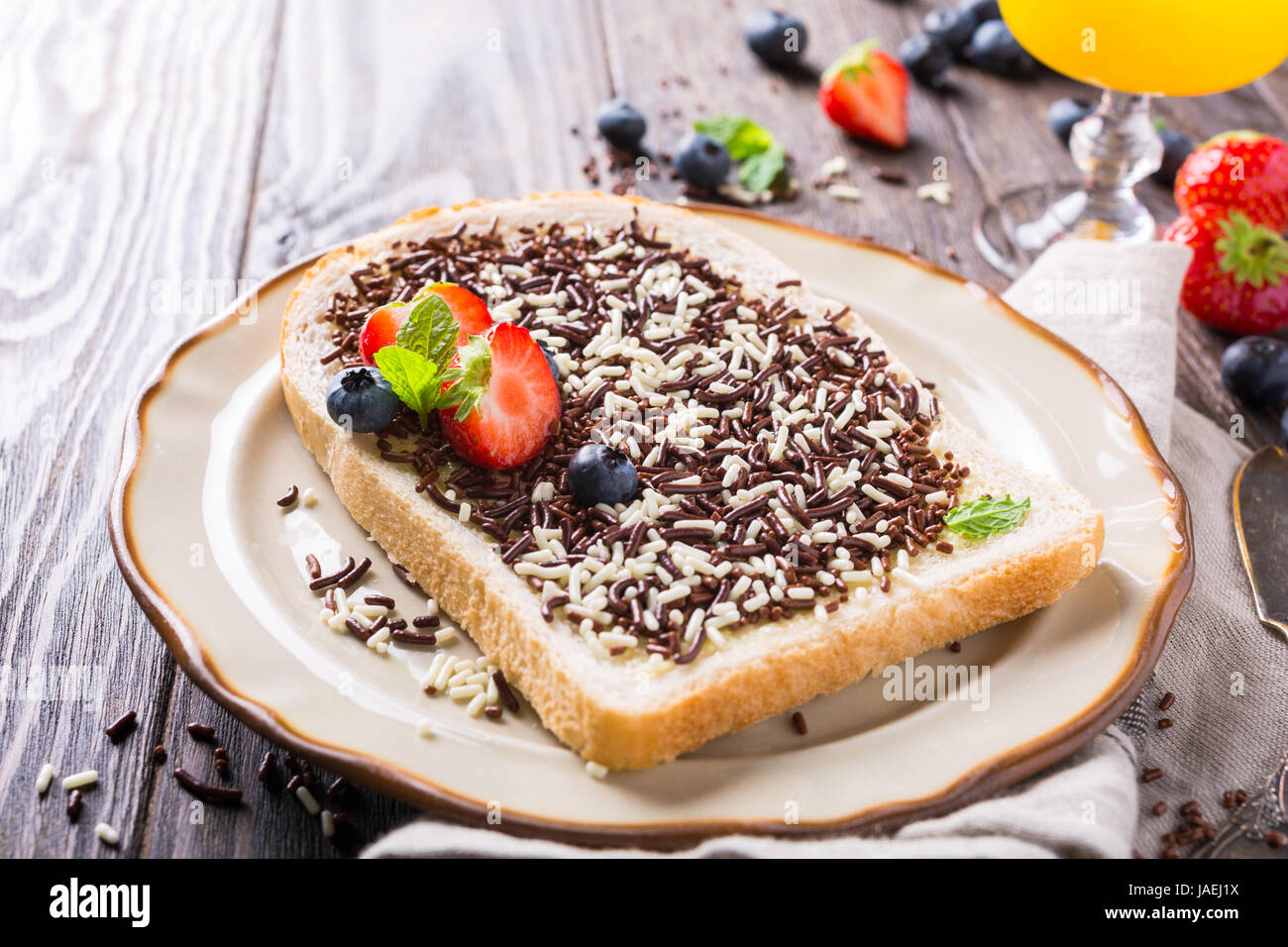 Dutch breakfast, slice of bread with hagelslag chocolate sprinkles and berries Stock Photo Alamy
