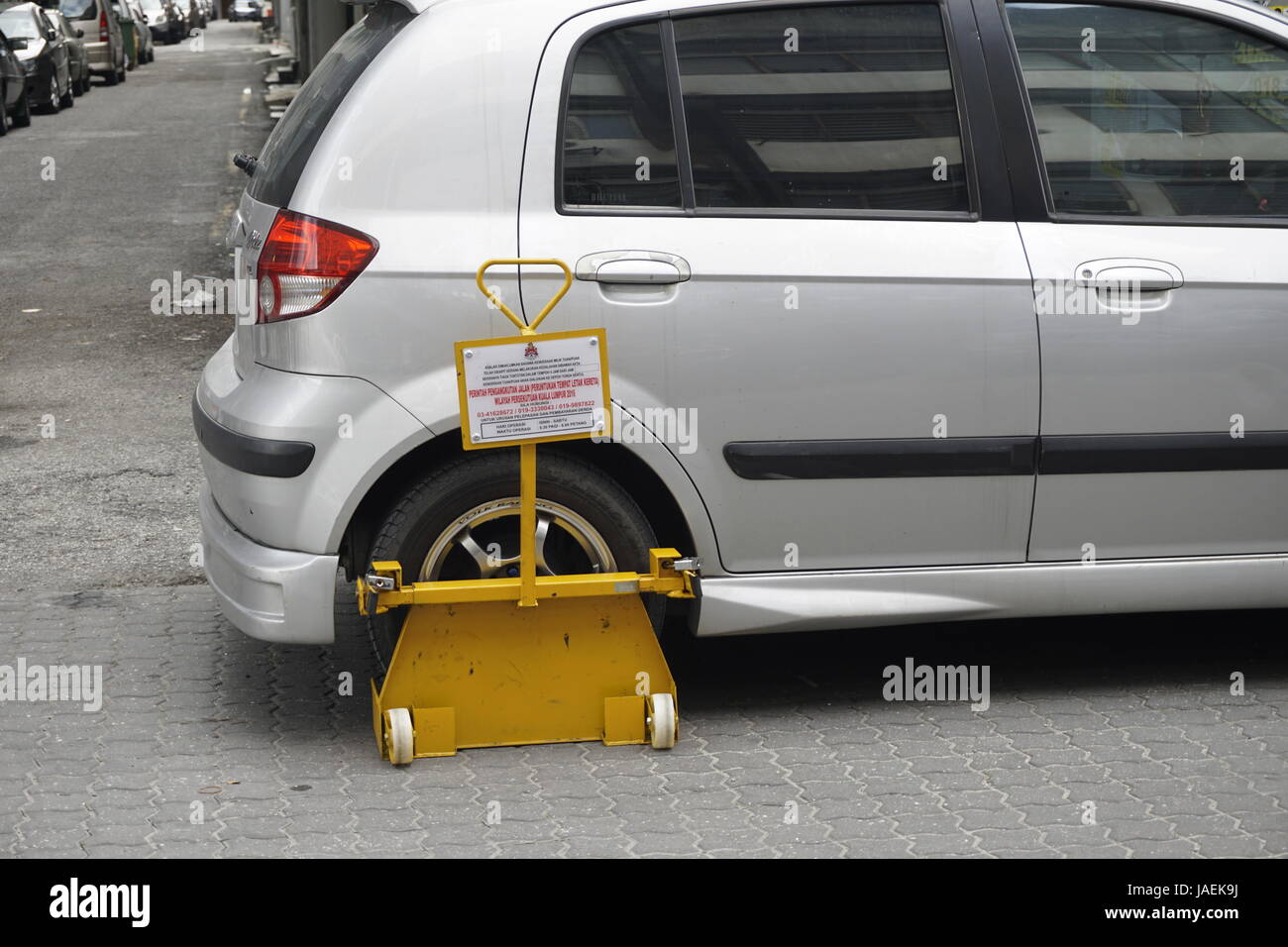 car wheel clamped for illegal parking in Malaysia Stock Photo