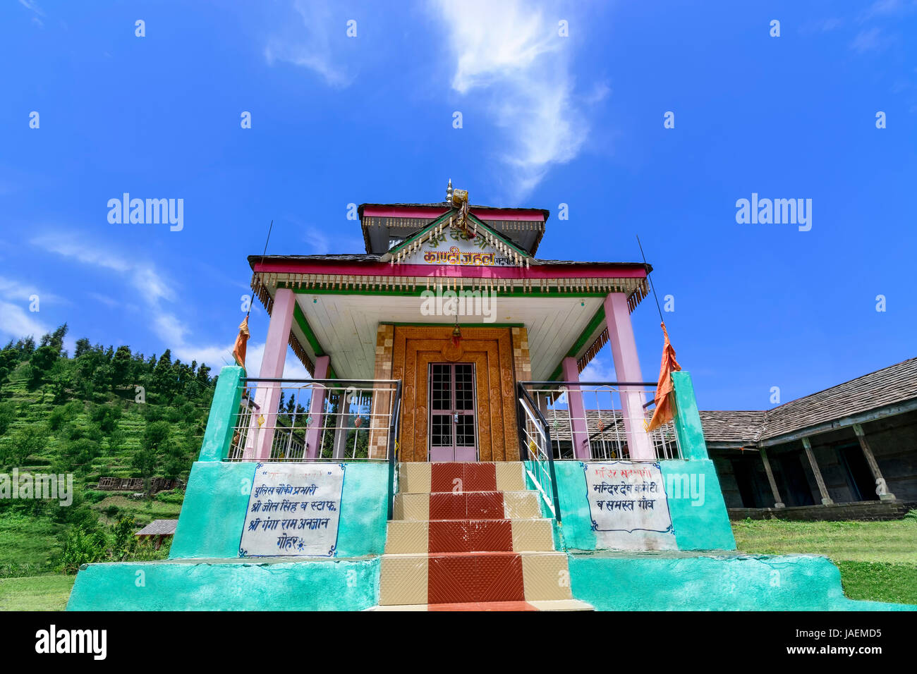 Beautiful multi colored Hindu temple in the picturesque setting of the majestic Janjehli Valley in Himalayas, India Stock Photo