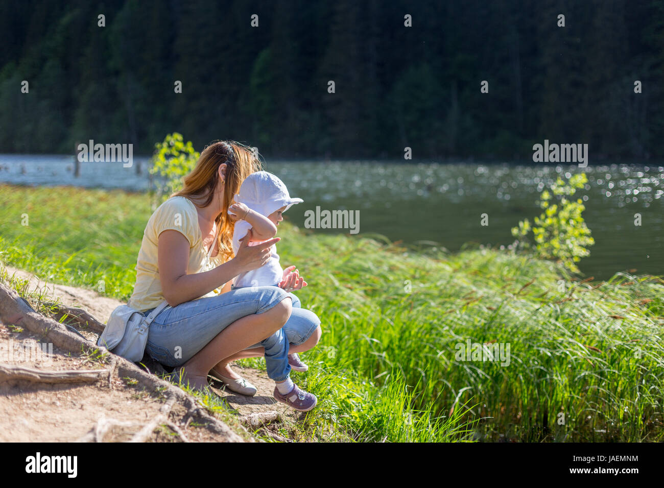 Mother and baby girl throwing rocks in the water Stock Photo Alamy